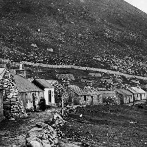 The village of St Kilda nestling at the foot of a bare rugged rock on the main island of