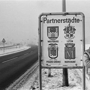 Volkswagen assembly line worker Peter Schredewitz leaning against the Wolfsburg town sign
