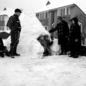 Weather - Snow - Cold Children building a snow house / igloo in the street - waving