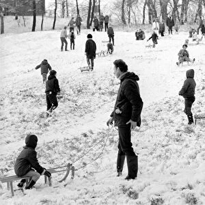 Weather snow scenes at Hampstead Heath. Winter: Everyone enjoys the first London snow