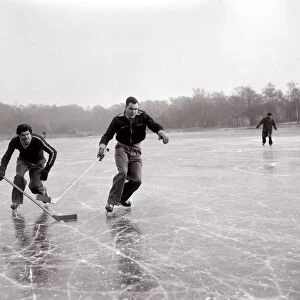 Weather Winter Scenes 1954 Two boys playing ice hockey on a frozen lake in winter