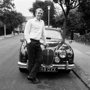 West Ham United Kapitän Bobby Moore im Bild neben seinem Jaguarkar zu Hause. West Ham United Kapitän Bobby Moore im Bild neben seinem Jaguarkar zu Hause.