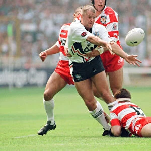 A Widnes player is pounced upon by three of the Wigan defence during the Rugby League Cup