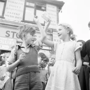 Winners of the Ice Lollipops sucking contest hold their winning aloft