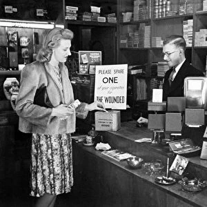 A woman buying a packet of cigarettes in a tobacconist shopin London