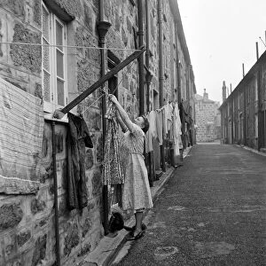 A woman hanging out her washing in a street in St Ives, Cornwall. 15th February 1954