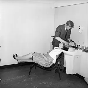 Woman having her hair washed at the John London Hair and Beauty Saloon. 1960