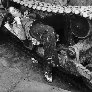A woman in a Ministry of Supply munitions depot works on the catapillar track of a tank