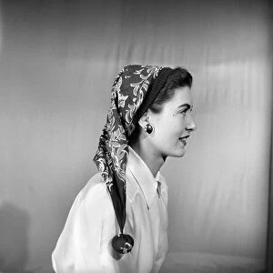 Woman modeling several ways of wearing a head scarf. April 1953
