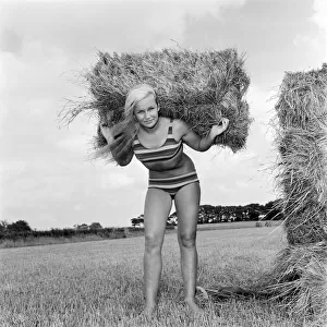 Woman modelling beachwear in a field during harvest