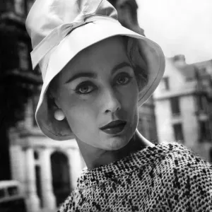 A woman modelling a fashionable hat. July 1957
