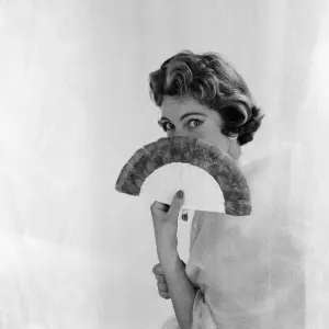 Woman pictured with a fan. Photographed for an article in The Daily Mirror by Helen Hugh Woman pictured with a fan. Photographed for an article in The Daily Mirror by Helen Hugh