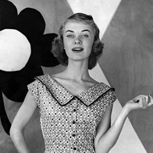 Woman poses wearing sleveless patterned blouse with large collar. July 1955 P012657