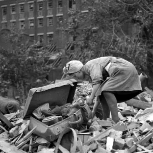A woman rummages through the debris of bomb damage at New Cross after air raids on London