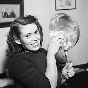 Woman seen in the kitchen drying a frying pan. Circa February 1952