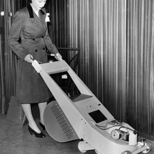A woman trying out a stream lined lawn mower which can be driven by petrol or electric A woman trying out a stream lined lawn mower which can be driven by petrol or electric