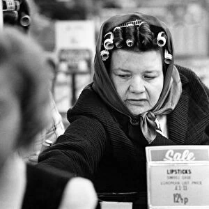 A woman wearing curlers in her hair enjoying shopping in the sales after Christmas