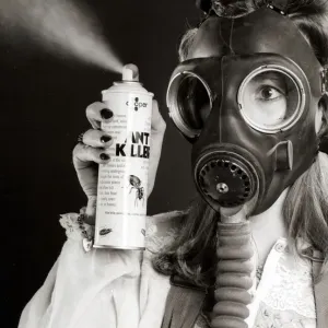 A woman wearing a protective gas mask holds Ant Killer Spray Print A woman wearing a protective gas mask holds Ant Killer Spray Print