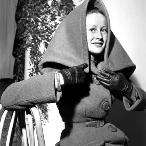 A woman wearing a woollen two piece fabric suit coat with a collar / hood A woman wearing a woollen two piece fabric suit coat with a collar / hood