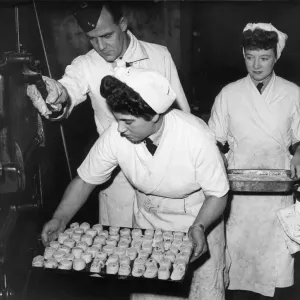 Women baking Swiss Rolls and sultana puddings, put their desserts into the oven during Women baking Swiss Rolls and sultana puddings, put their desserts into the oven during