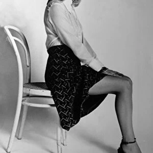 Women, beauty, culture. Model posing on edge of chair February 1977