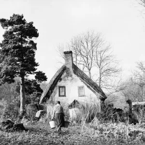 Women carrying buckets of water to her rural cottage, far from the world Women carrying buckets of water to her rural cottage, far from the world