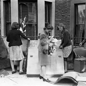 Women look through belongings from their homes after an air raid bombing. Cardiff, Wales