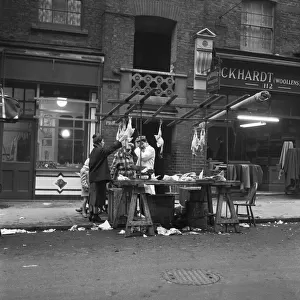 Women peruse kosher chickens at an un-named street market in the East End of London 11th