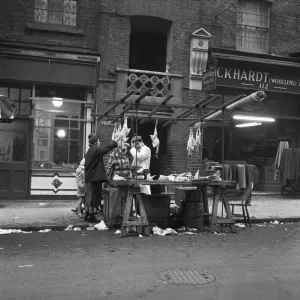 Women peruse kosher chickens at an un-named street market in the East End of London 11th