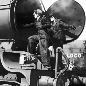 Women railway workers clean out a steam engine boiler during WW2. 1942