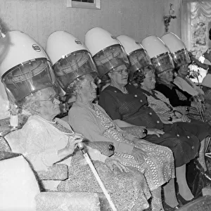 Women sitting at stand hair dryers in a salon