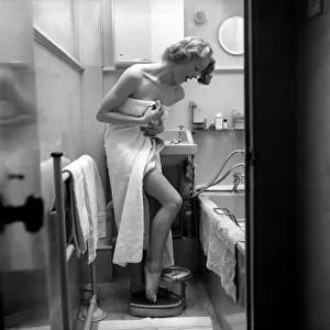 Women: Weight. Actress Pat Dainton weighing herself. October 1953 D5991-001