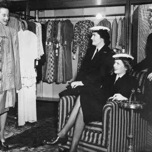 A black and white print of women in naval service purchasing clothing A black and white print of women in naval service purchasing clothing