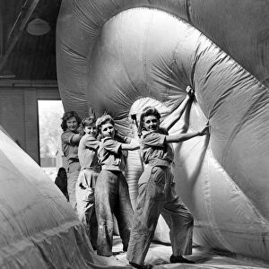 Women working in a barrage balloon factory haul a section into position. WW2 1943