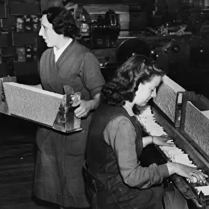 Women working on a cigarette production line. Cigarettes being manufactured at the rate