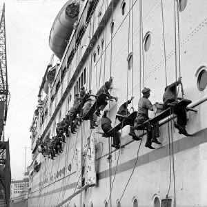 Workers cleaning the Empress of Australia liner at Southampton dock following