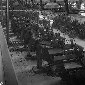 Workers feeding tobacco leaf in to machines at the start of the cigarette manufacture in Workers feeding tobacco leaf in to machines at the start of the cigarette manufacture in