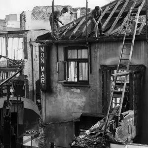Workmen busy demolishing old property in Queen Street, Cardiff. 6th April 1960