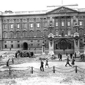 Workmen clear up the rubble outside Buckingham Palace after a daylight raid in 1940