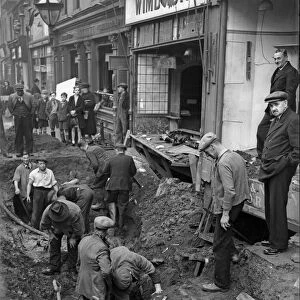 Workmen inspect a crater in central Birmingham following a raid on the city