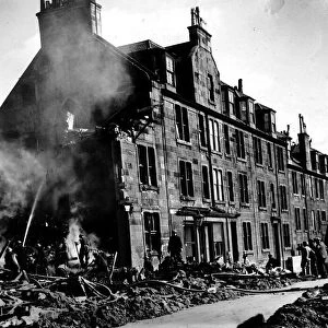 World War Two Firemen damp down a fire at a Scottish tenement block after a German air