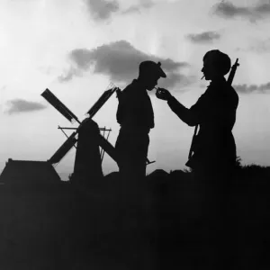 World War Two. Eventide in Holland'. British Soldiers pause to light their World War Two. Eventide in Holland'. British Soldiers pause to light their
