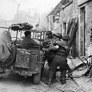 Wounded being loaded into jeeps during the capture of Caen. 9th July 1944