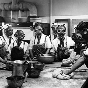 WW2 Army cookery school, June 1941. Women wearing gas masks while watching a