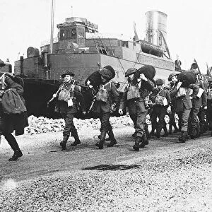 WW2 British soldiers disembark from a troop ship in France carrying their kit bags