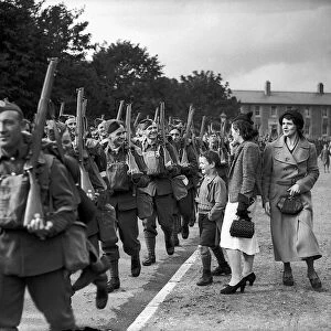 WW2 British Soldiers in England march along the road past family