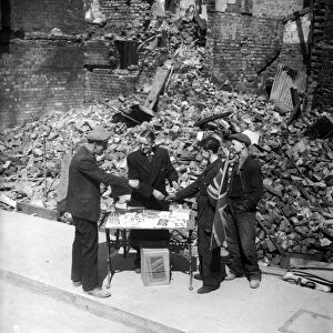 WW2 Tobaconist sales cigarette outside his bombed shop