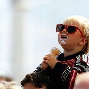 Two year old Craig Emmerson enjoys an ice cream whist watching an air display at