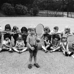 Three year old Daniel Jarmin holds a tennis racket as he poses with other friends in his
