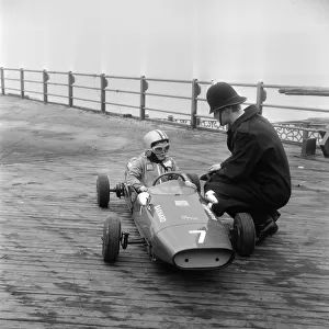 Eight year old Thomas Barnard in his racing car, speaking to a policeman on the West Pier